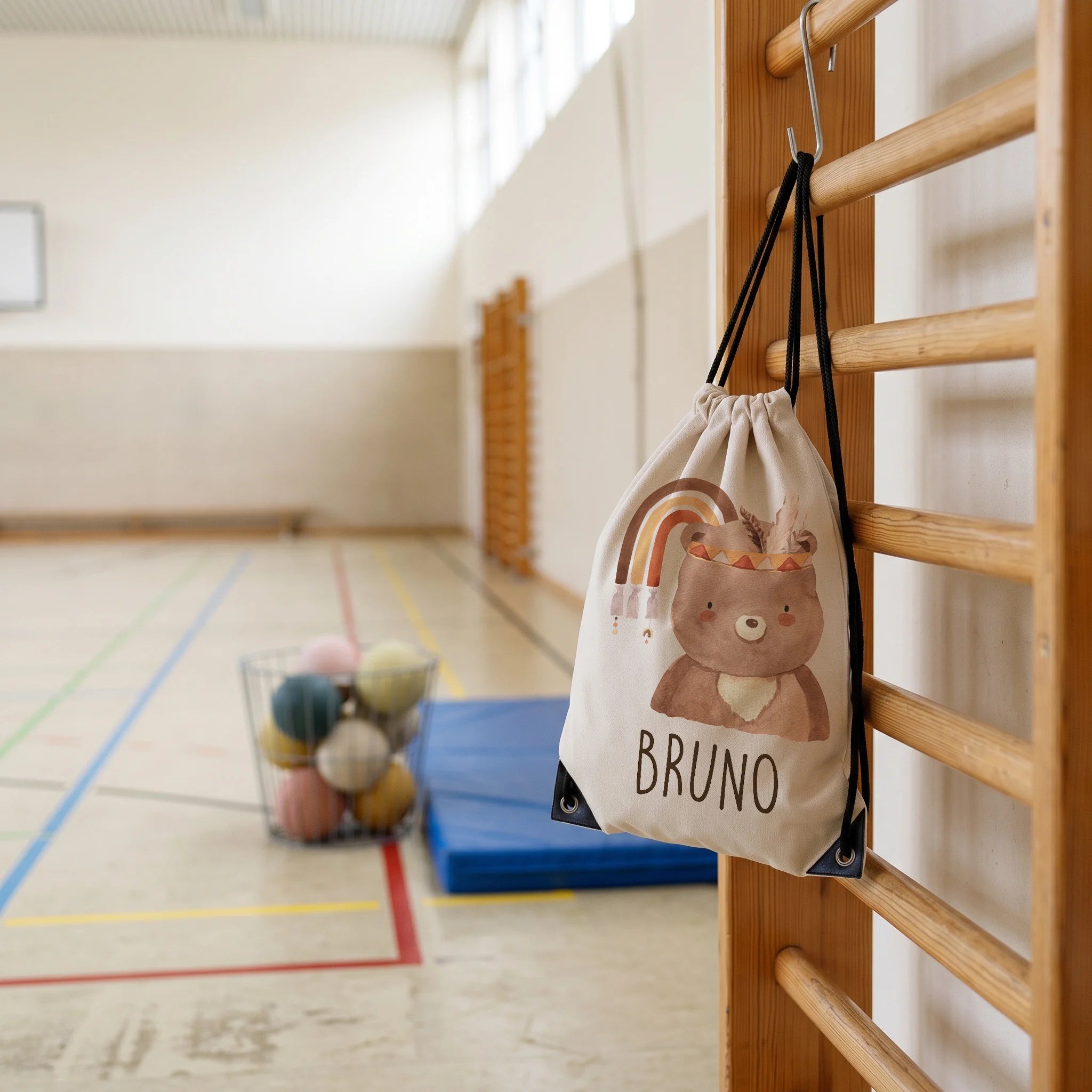 Personalisierter Turnbeutel BĂ€r mit Regenbogen, im Sportunterricht in der Turnhalle