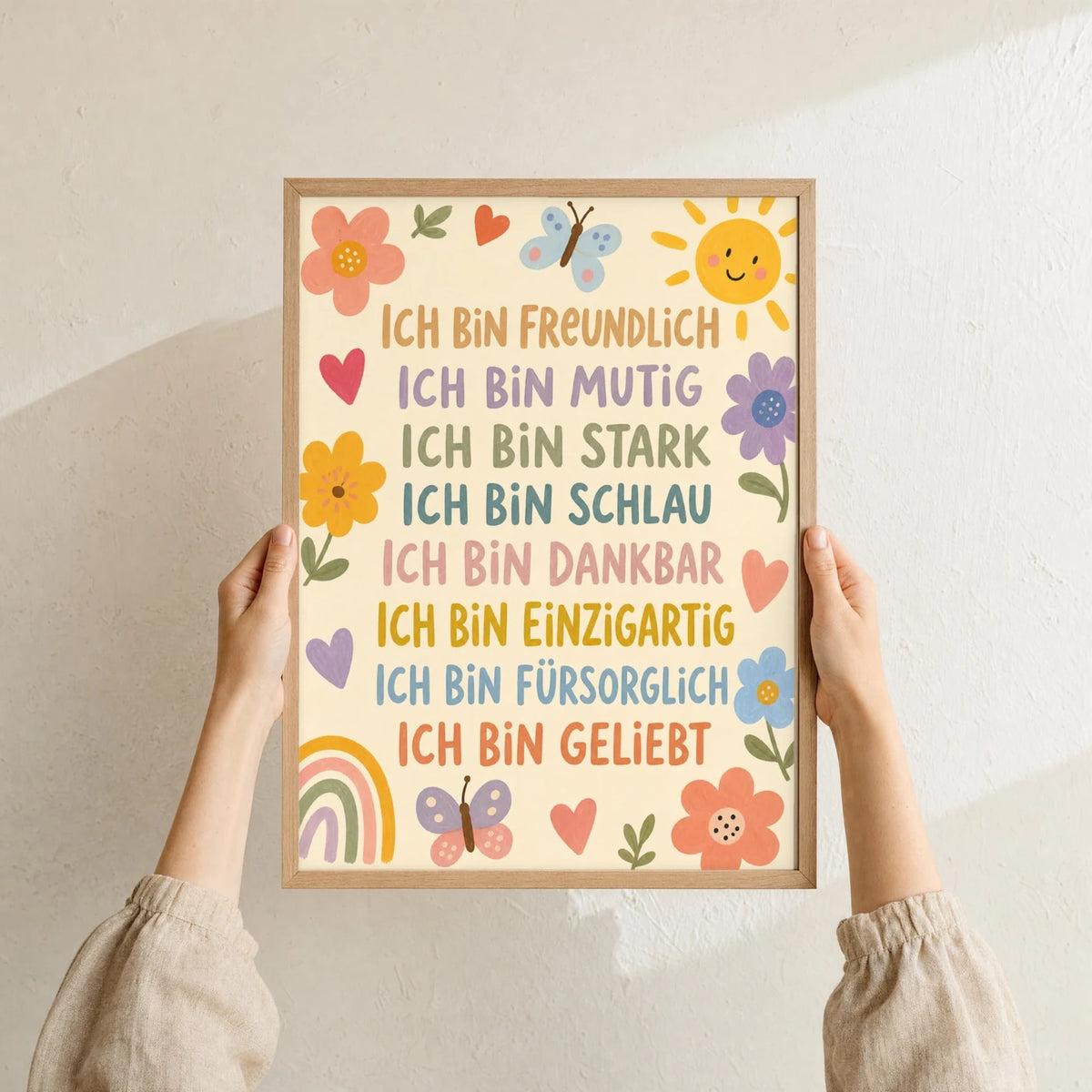 Affirmationsposter „Blumenwiese Ich bin freundlich“ im Holzrahmen in den Händen gehalten – Taufgeschenk und Kinderzimmer Deko