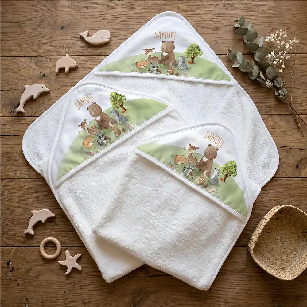 Personalisiertes Kapuzenhandtuch Baby Waldparade – Flatlay mit Eukalyptus und Beißring